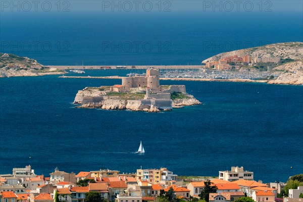View of Marseille town and Chateau d'If castle famous historical fortress and prison on island in Marseille bay with yacht in sea