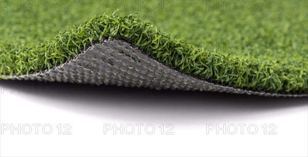 Flipped up section of artificial turf grass on white background