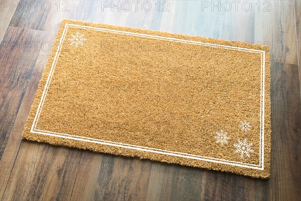 Blank holiday welcome mat with snow flakes on wood floor background