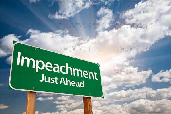 Impeachment green road sign with dramatic clouds and sky
