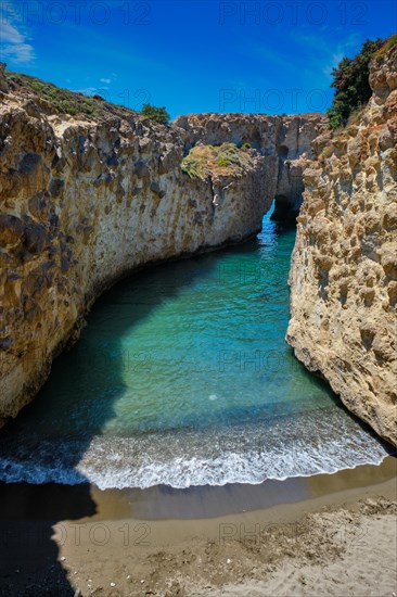 Papafragas hidden beach with crystal clear turquoise water and tunnel rock formations in Milos island