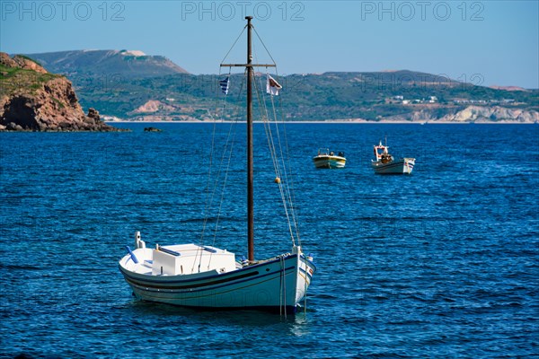 Traditional greek fishing boat in the Aegean sea with greek flag