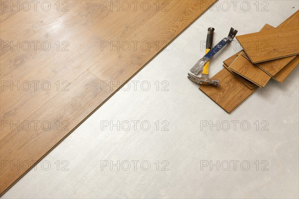 Worn hammer and pry bar with laminate flooring abstract with copy room