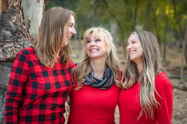 Beautiful mother and young adult daughters portrait outdoors