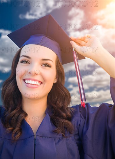 Happy graduating mixed-race woman in cap and gown