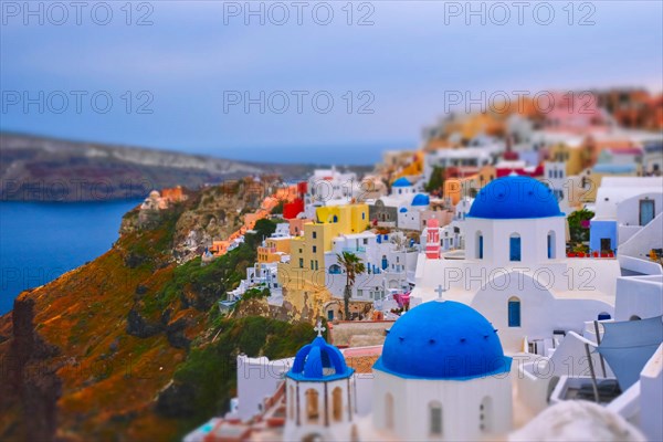 Famous greek iconic selfie spot tourist destination Oia village with traditional white houses and church in Santorini island on sunset in twilight