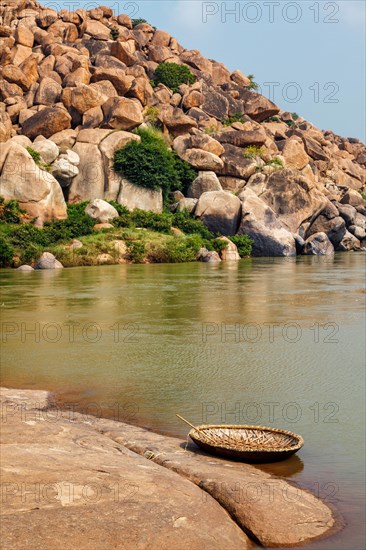 Traditional wickerwork coracle boat in Hampi on bank of Tungabhadra river