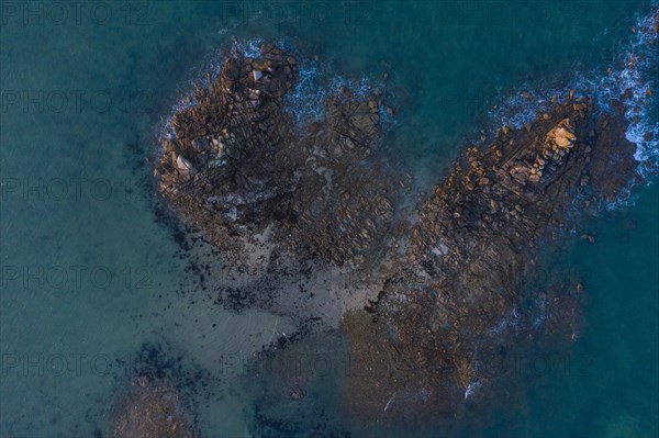 Aerial view of rock formations in the sea in front of the sandy beach Ker Emma shortly in front of sunset