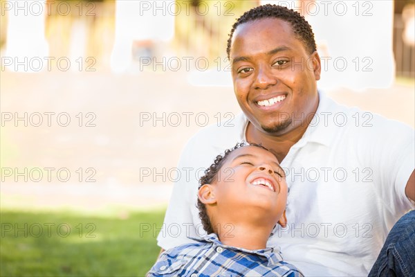 Happy african american father and mixed-race son playing at the park