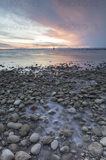 Sunrise on a wintry lake in bad weather