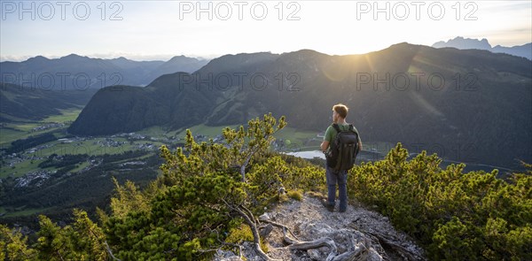 Hiker standing on hiking path between mountain pines