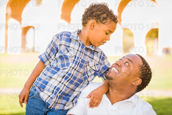 Happy african american father and mixed-race son playing at the park