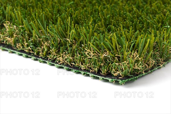 Section of artificial turf grass on white background