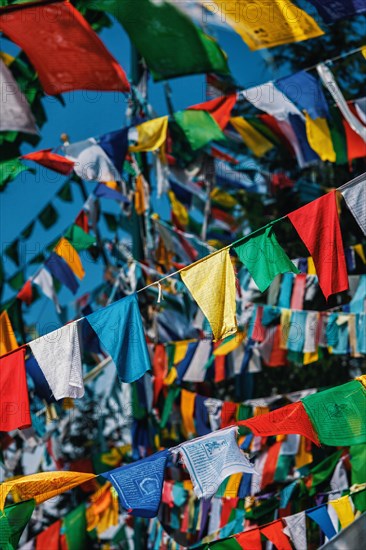 Buddhist prayer flags lungta with Om Mani Padme Hum Buddhist mantra prayer meaning Praise to the Jewel in the Lotus on kora around Tsuglagkhang complex