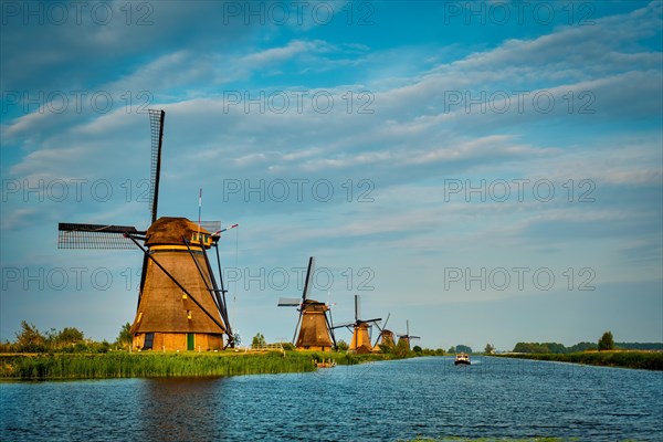 Netherlands rural lanscape with windmills at famous tourist site Kinderdijk in Holland on sunset with dramatic sky