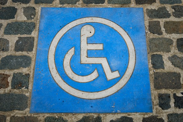 Disabled handicapped Parking Sign on cobblestone parking lot