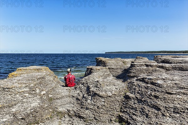 Hiker sitting between limestone columns