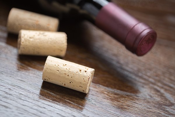 Wine bottle and corks on a reflective wood surface abstract