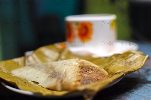 Stuffed tamale served on wooden table