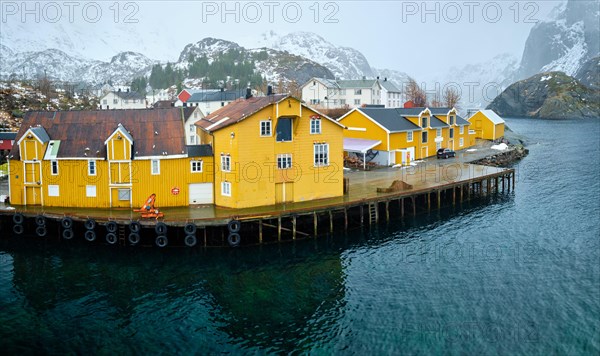 Panorama of Nusfjord authentic fishing village with yellow rorbu houses in Norwegian fjord in winter. Lofoten islands