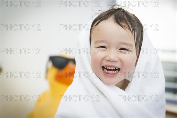 mixed-race boy having fun at the water park with large rubber duck in the background