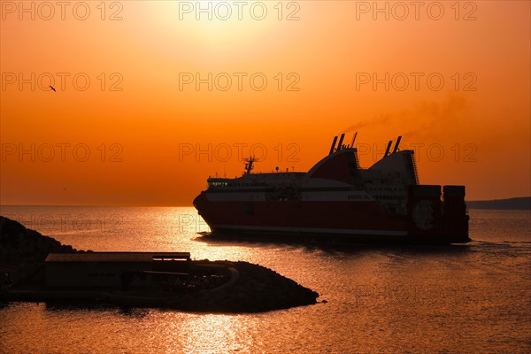 Ferry vessel in sea departing port of Marseille for Corsica on sunset