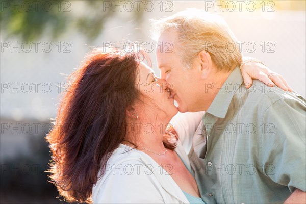 Happy middle aged couple enjoy A romantic slow dance and kiss outside