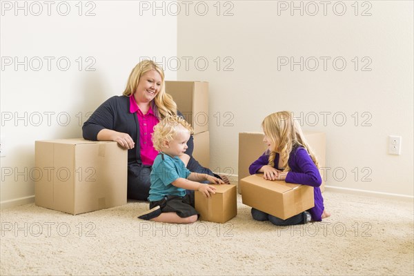 Happy young family in empty room with moving boxes