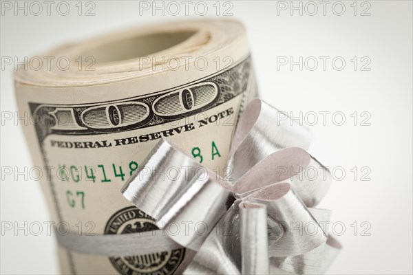 Roll of one hundred dollar bills with silver bow on white