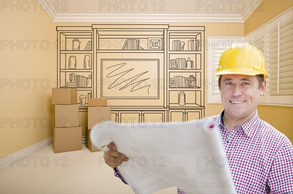 Male construction worker wearing hard hat in room with drawing of entertainment unit on wall