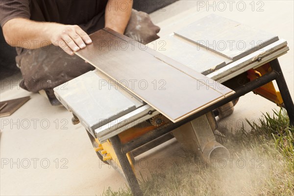 Contractor using circular saw cutting of new laminate flooring renovation