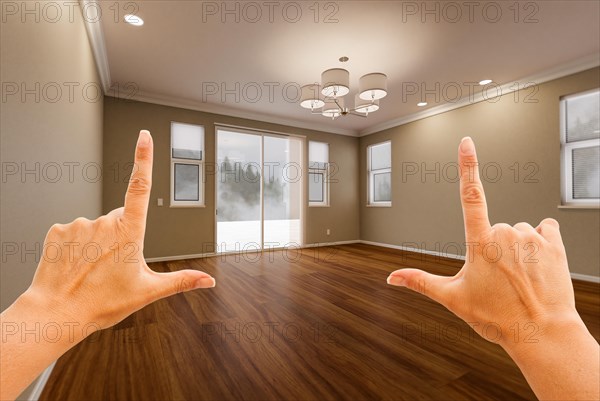 Female hands framing empty room of new house