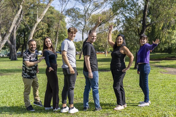 Multi ethnic family group walking arm in arm in a park