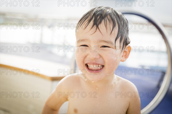 mixed-race boy having fun at the water park with large rubber duck in the background