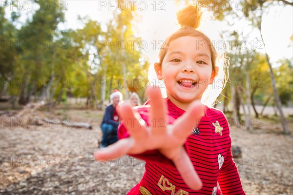 Cute mixed-race baby girl christmas portrait with family behind outdoors