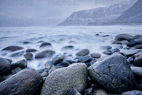 Waves of Norwegian sea surging on stone rocks at Unstad beach