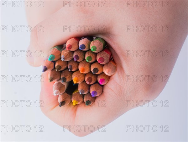 Hand holding color Pencils placed on a white background