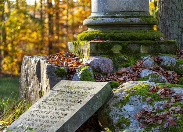 Historical column and stone slab with inscription in the park