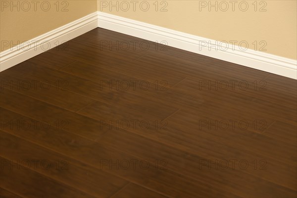 Beautiful newly installed brown laminate flooring and baseboards in home