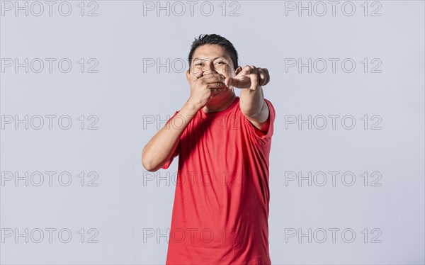 Isolated attractive guy laughing at you