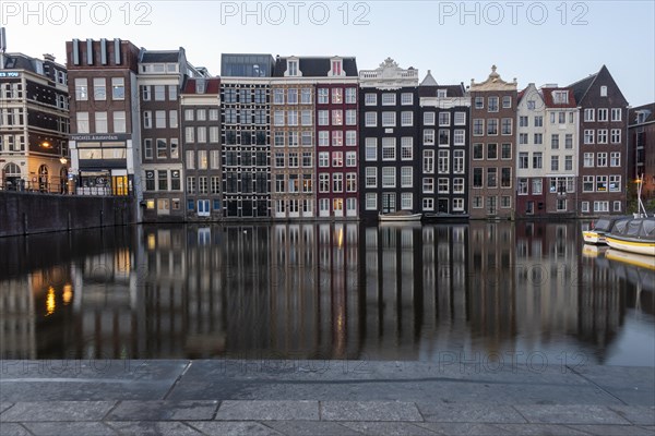 Characteristic residential buildings reflected in the Damrak Canal