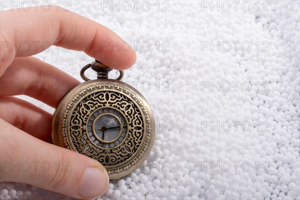 Retro style pocket watch in hand on white background