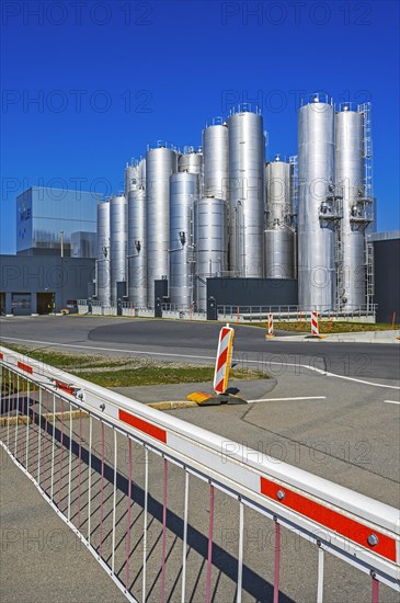 Schranke vor Fabrik mit Hochsilos