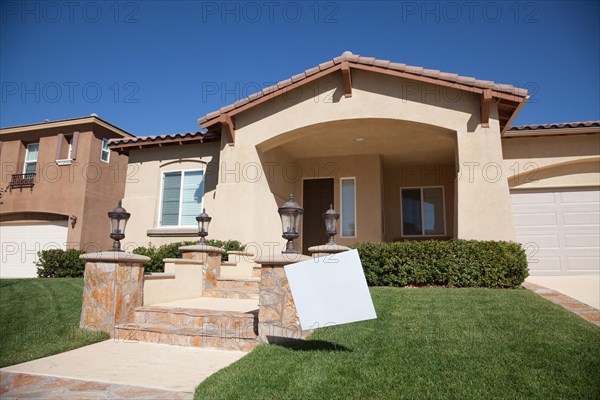 Blank real estate sign in front of beautiful new home