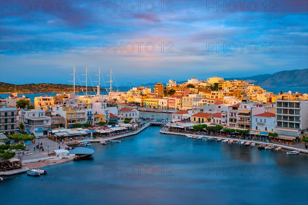 Beautiful Agios Nikolaos town on lake Voulismeni on sunset. Lasithi region of Crete island