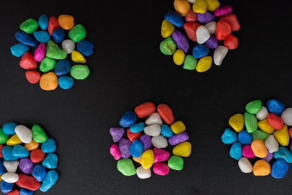 Pile of little colorful pebbles on black background