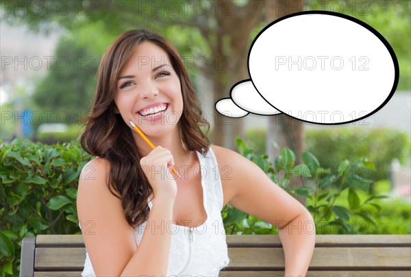 Thoughtful young woman with pencil and blank thought bubble