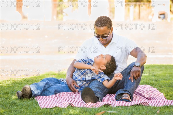 Happy african american father and mixed-race son playing at the park