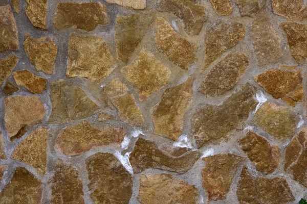 Damp natural stone wall with efflorescent saltpetre Salt