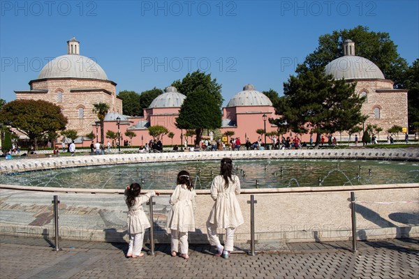 Three little girls by the pool with domes in Istanbul